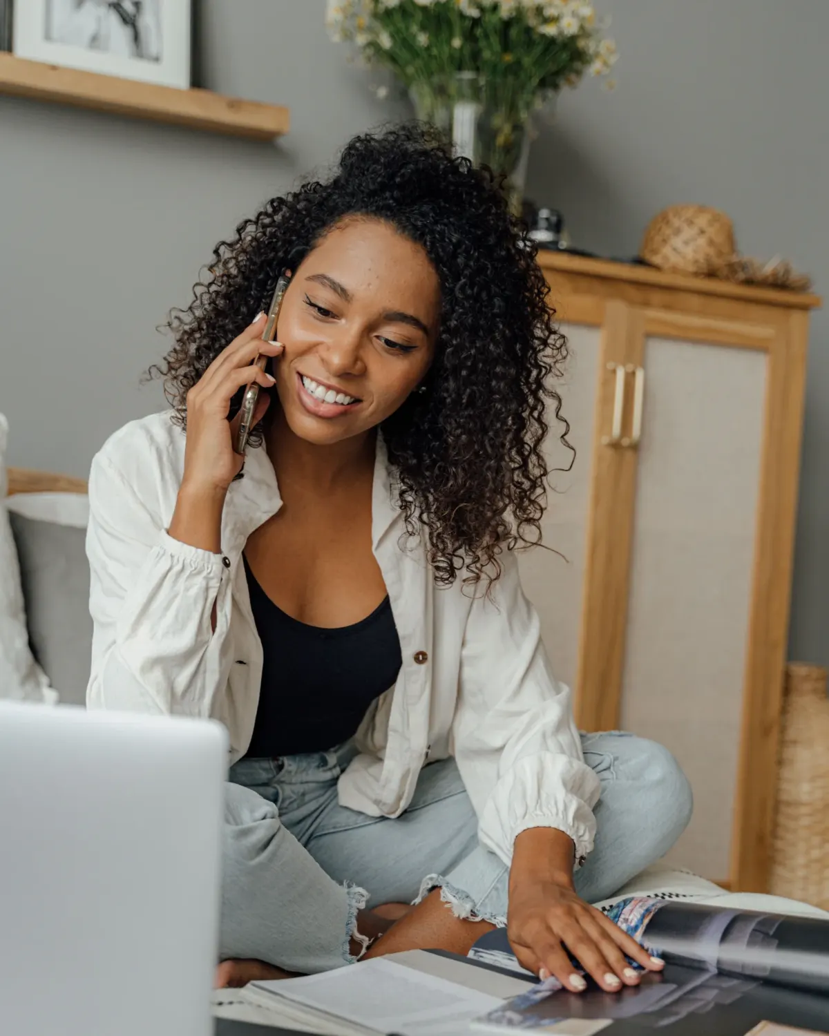 A young woman smiling as she chats on the phone at home